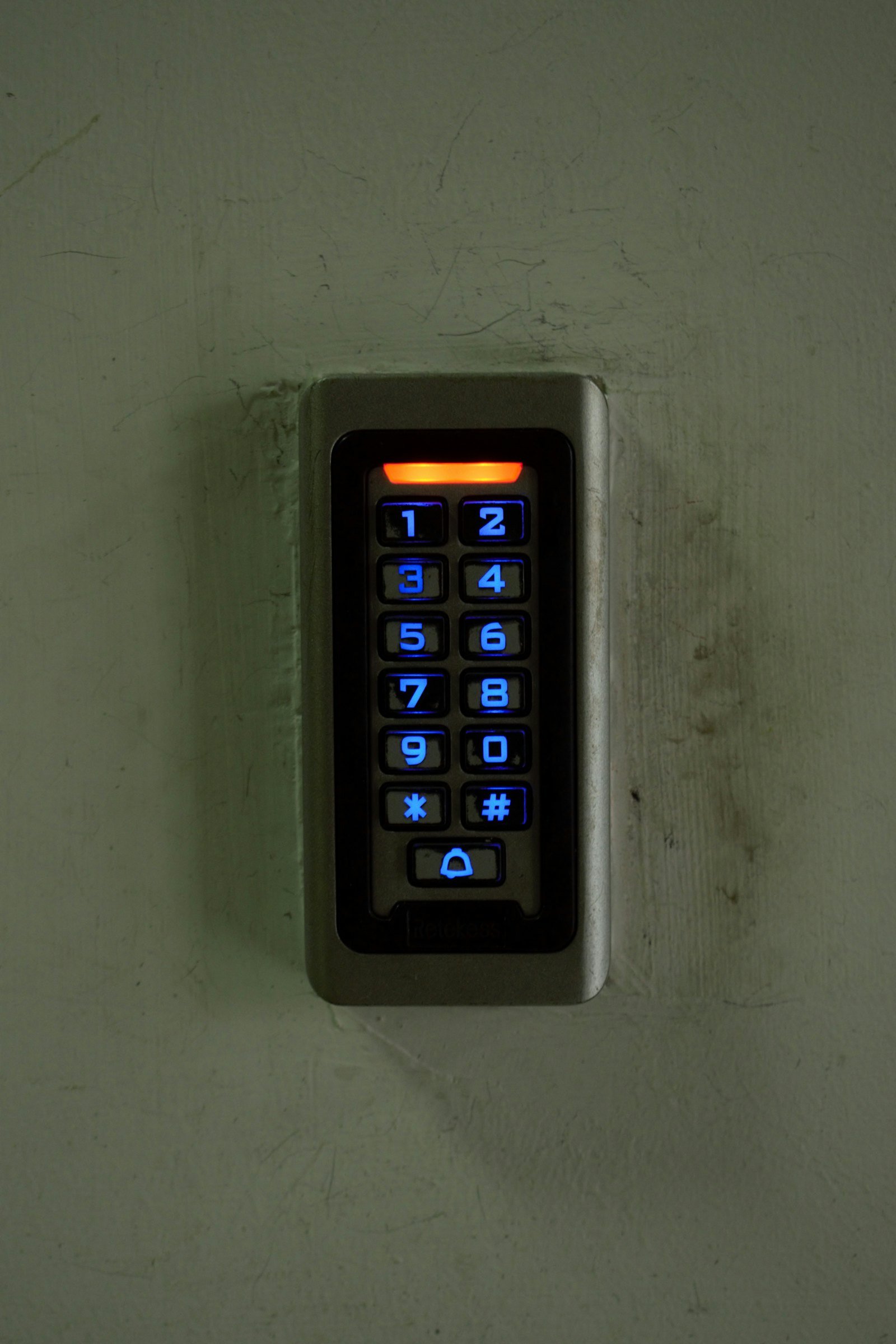 Lecteur de badge et de code fixé à un mur