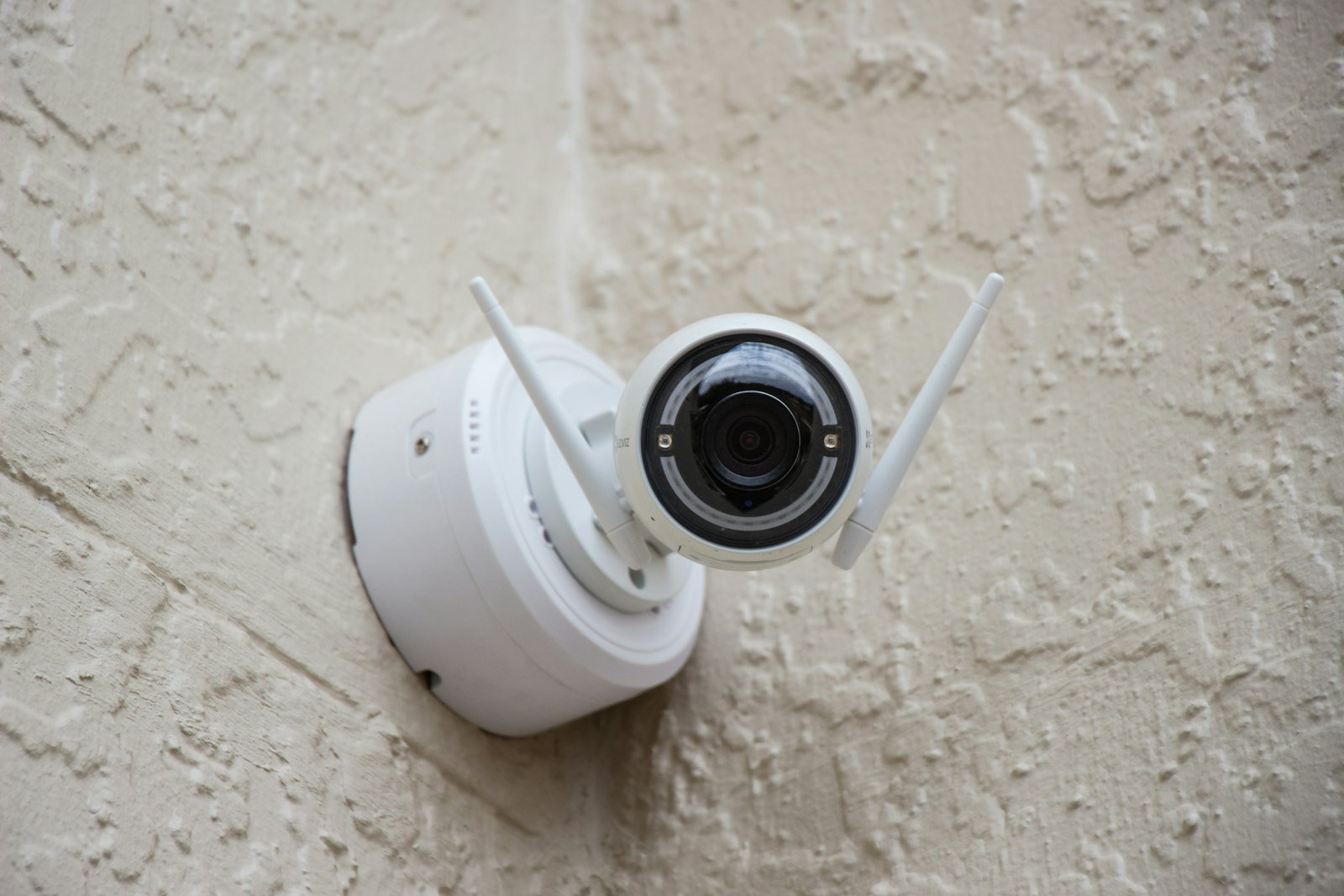 Caméra de surveillance blanche fixée à un mur