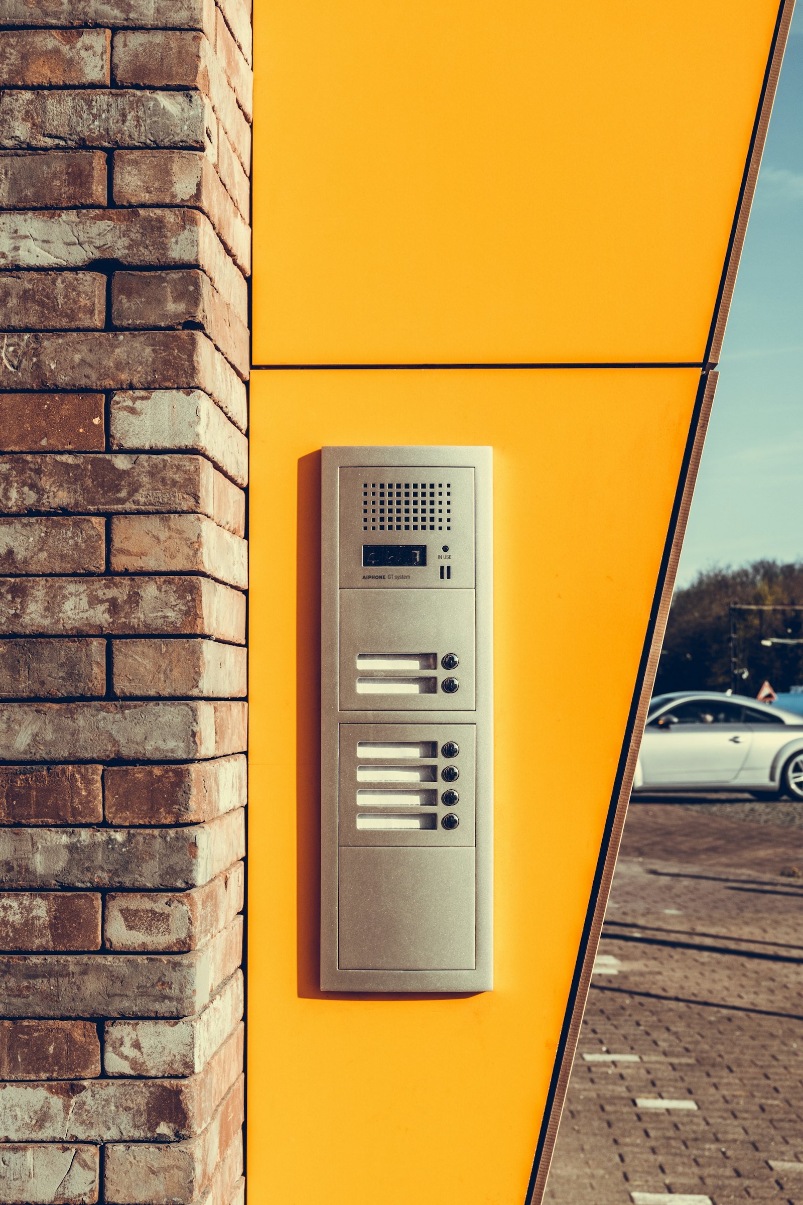 Interphone fixé sur un mur jaune